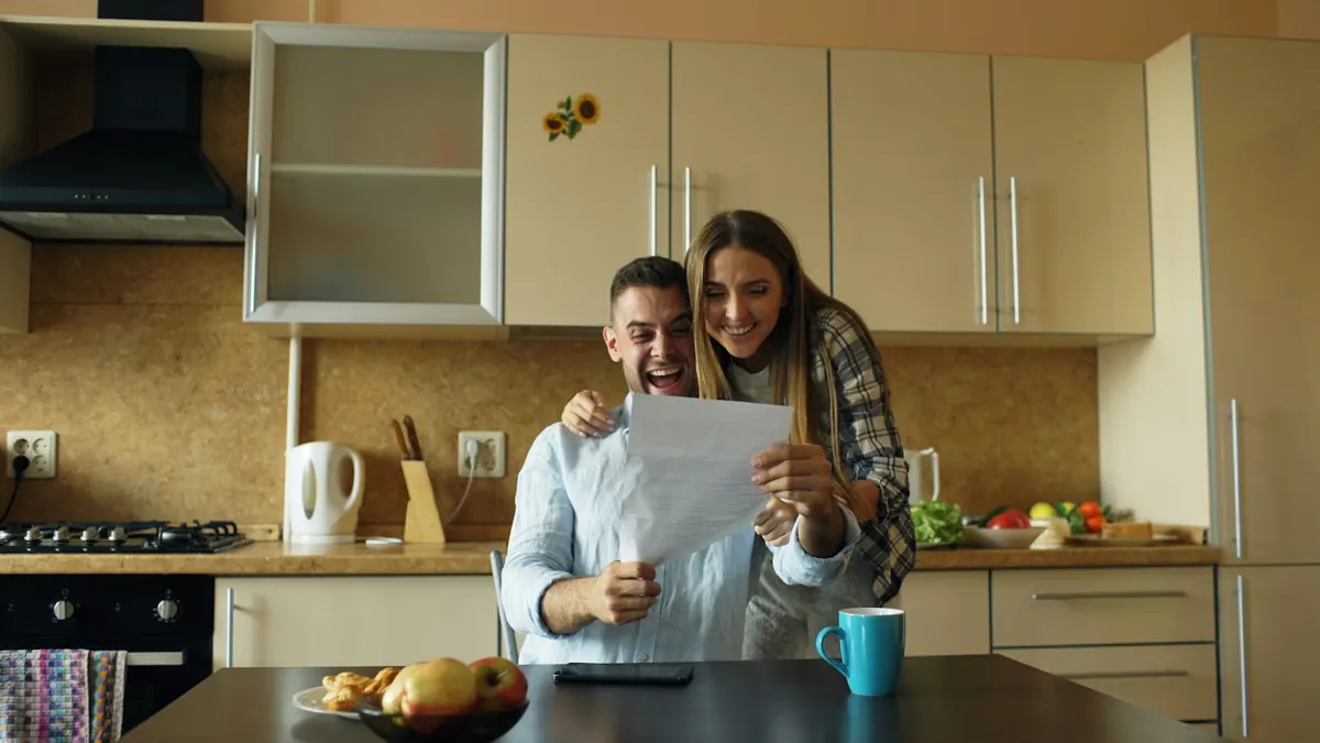 Pareja contenta mirando un documento en la cocina